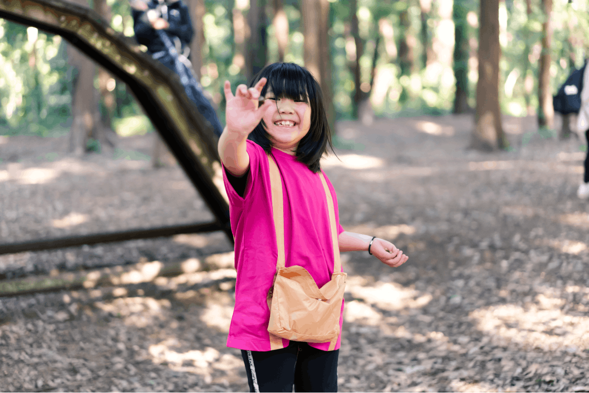 アップサイクルTシャツを着てどんぐり拾いを楽しむ女の子