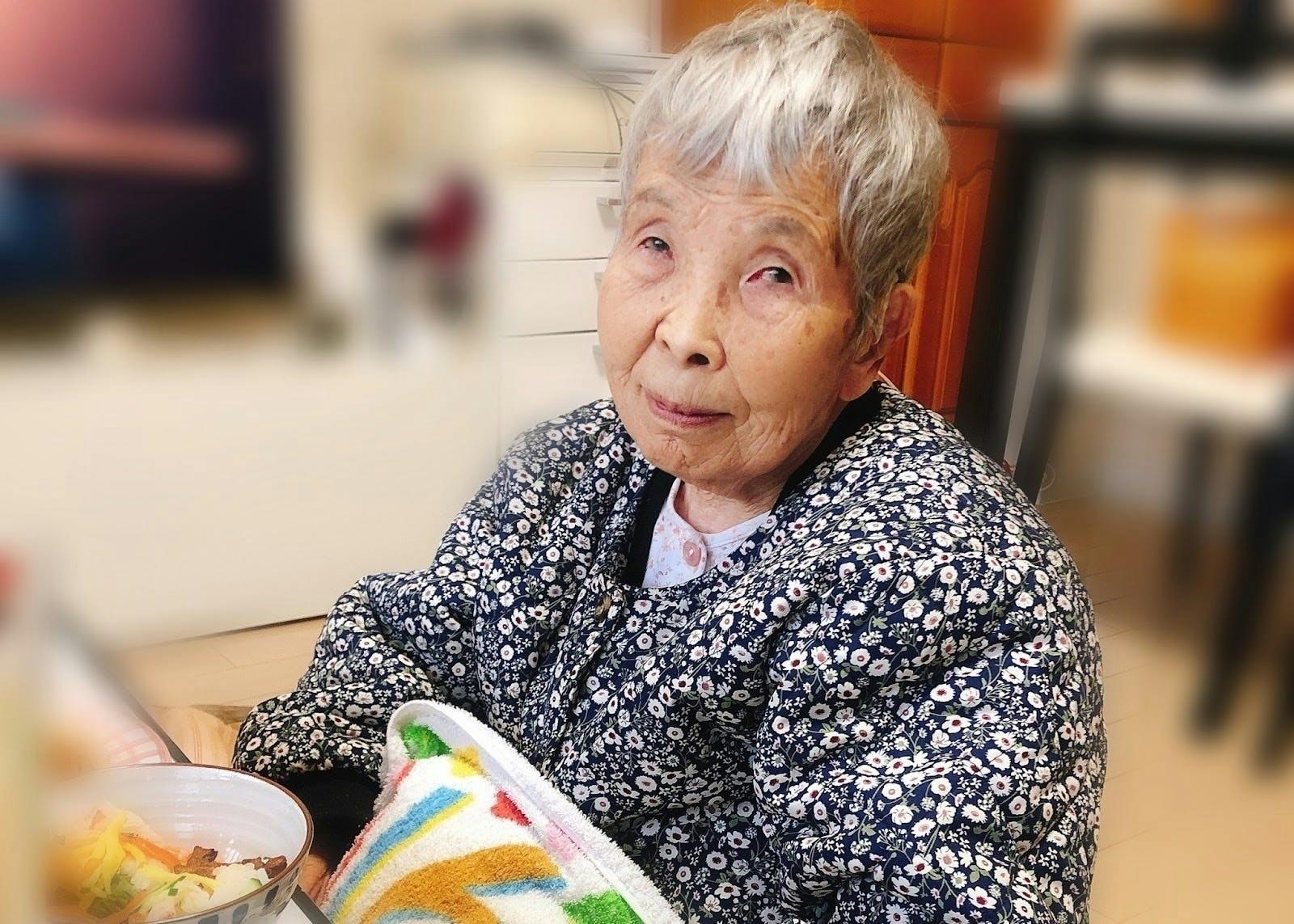 代表田村の祖母の写真 机の前に座り身体を斜めにしてこっちを見ている写真