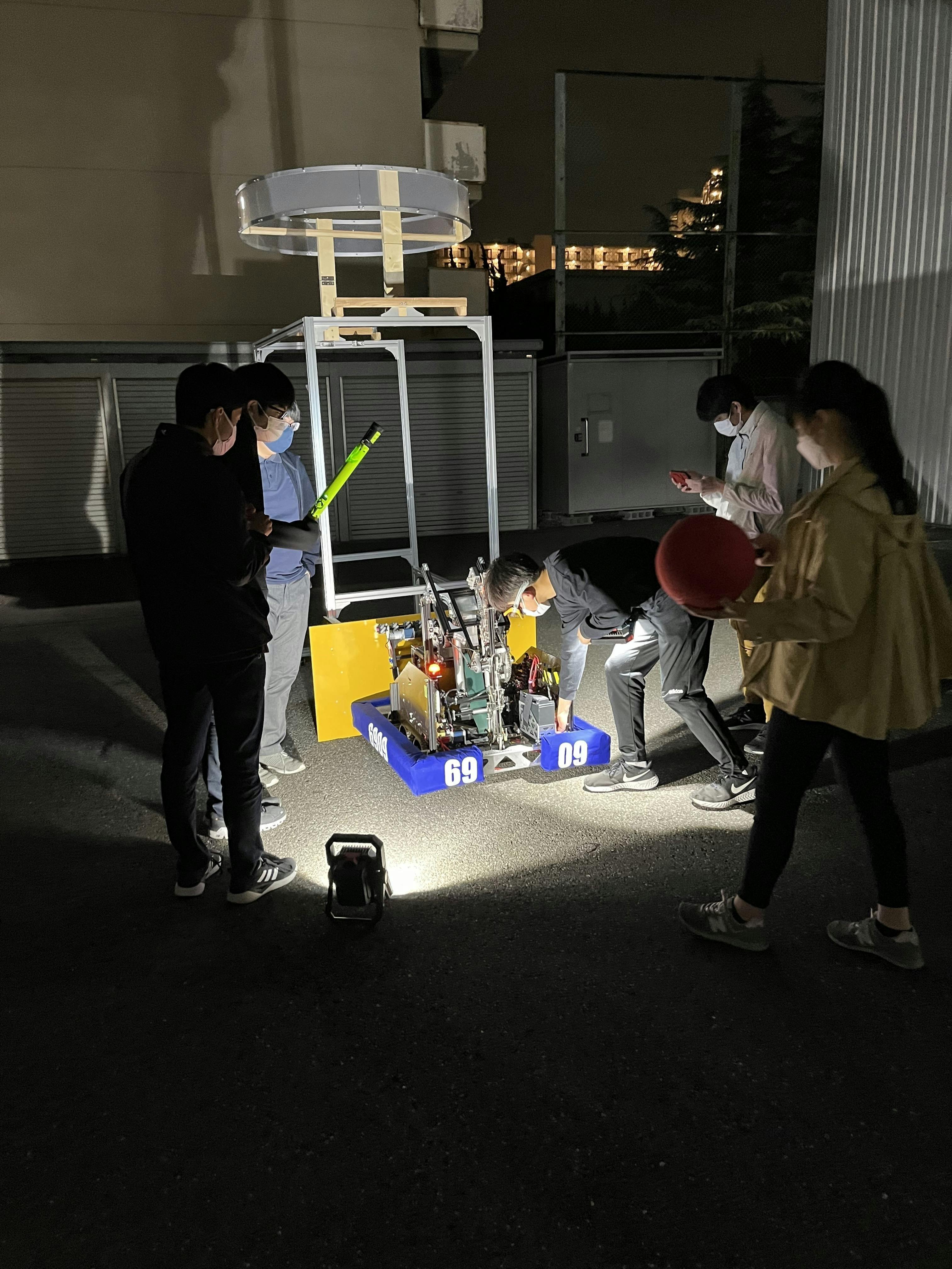 メンバーが夜遅くまでロボットの調整をしている様子