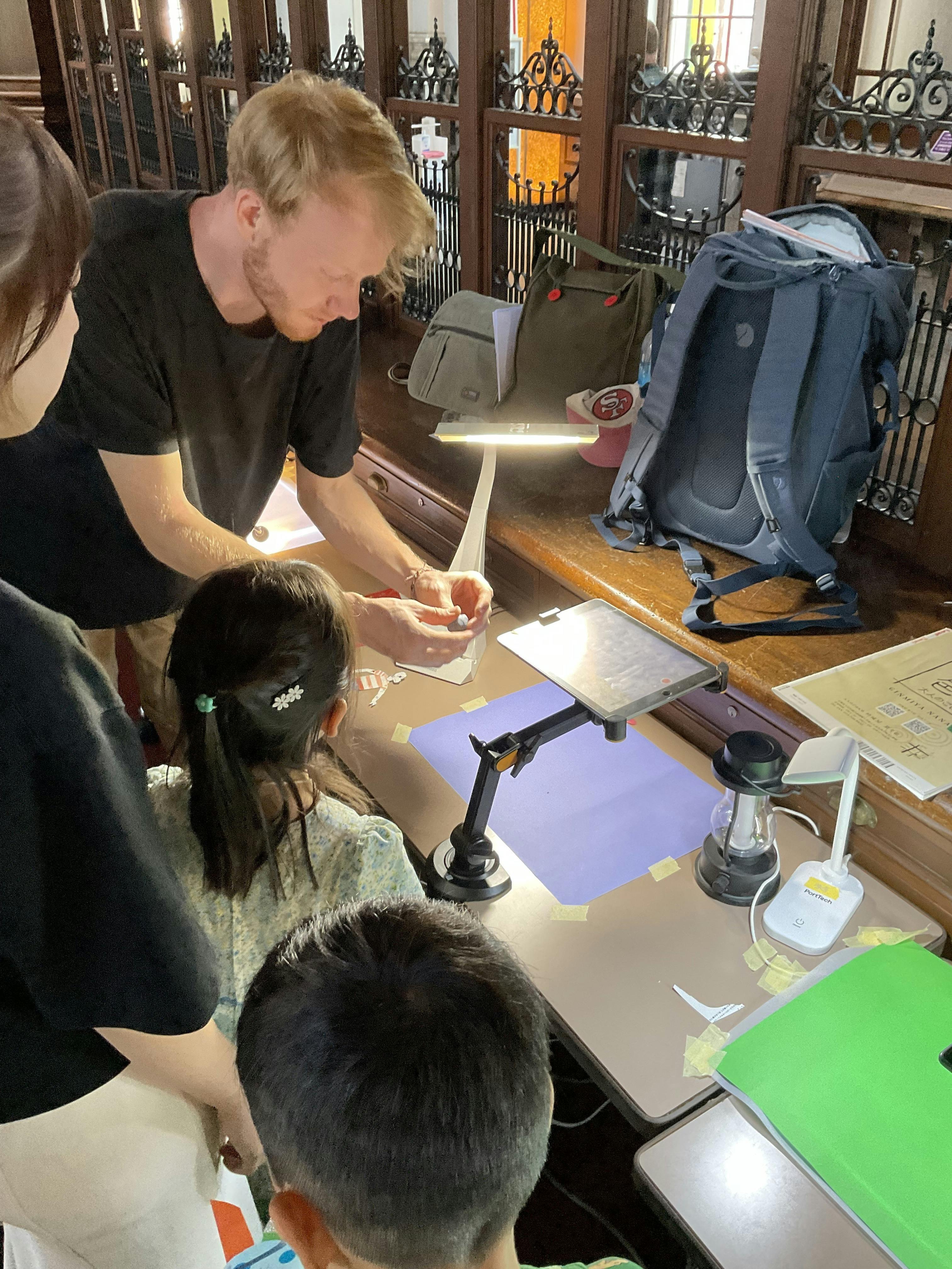 チェコから来日したヤン監督による、アニメーションワークショップの様子。ヤン監督が実演するところをワークショップ参加者数名が見ている。