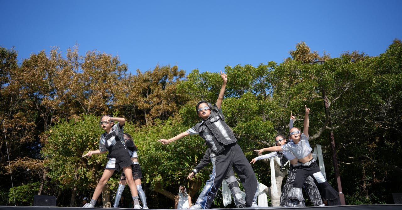西宮市で開催された野外イベントにて、サングラスをかけてカッコよく踊る子どもたち。シルバーの衣装で未来感のあるステージです。